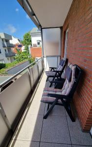 2 sedie sedute su un balcone su un edificio di Haus Götting Wohnung 2 a Norderney