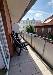 un balcone con 2 sedie e un frigorifero in un edificio di Haus Götting Wohnung 2 a Norderney