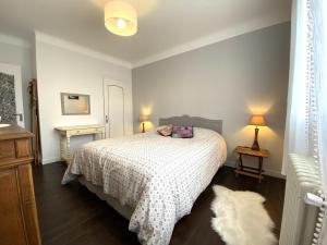 ein Schlafzimmer mit einem Bett mit einer weißen Decke in der Unterkunft La barthe in Biarritz