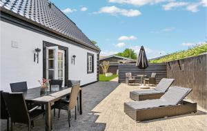 un patio con mesa, sillas y sombrilla en Cozy Home In Skagen With Kitchen, en Skagen