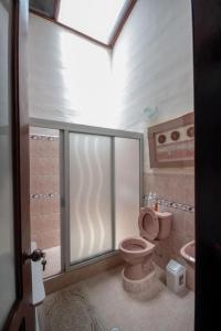 a bathroom with a pink toilet and a sink at Vilcabamba casa / granja Vilcabamba house / farm in Loja