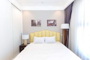 a bedroom with a large bed and two lamps at Altara Apartment Quy Nhon in Quy Nhon