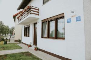 a white house with windows on the side of it at Apartman Nikola in Gospić