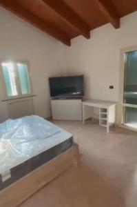 a bedroom with a bed and a tv and a desk at Appartamento moderno con 2 camere grandi e lavanderia in Brescello