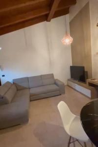 a living room with a couch and a tv at Appartamento moderno con 2 camere grandi e lavanderia in Brescello