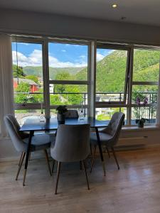 a dining room with a table and chairs in front of a window at Bergen Bliss: Mountain View in Bergen