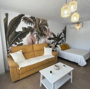 ein Wohnzimmer mit einer Couch, einem Bett und einem Tisch in der Unterkunft Selvática Studio Torre del Mar in Torre del Mar + 16 Fotos
