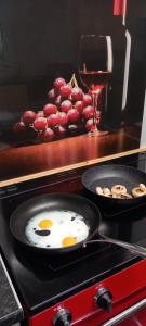 a frying pan with two eggs and a glass of wine at Ty Castell Guest House in Caerphilly