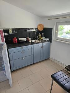 a kitchen with blue cabinets and a sink and a window at Studio D'Amalia in Turda +18 photos