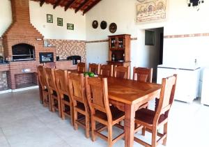 uma sala de jantar com uma mesa de madeira e cadeiras em Chácara Santa Luzia em Socorro