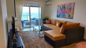 a living room with a couch and a tv in it at PORTO D'ORO LUXURY APARTMENT in Lavrio