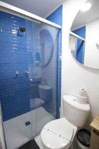 La salle de bains est pourvue de carrelage bleu, de toilettes et d'une douche. dans l'établissement Hospedaje privado cerca a Provenza en el Poblado - M301 By Roots Rentals, à Medellín