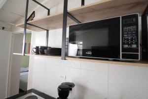 une cuisine avec un micro-ondes au-dessus d'un comptoir de cuisine dans l'établissement Hospedaje privado cerca a Provenza en el Poblado - M301 By Roots Rentals, à Medellín