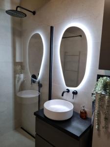 łazienka z umywalką i 2 lustrami w obiekcie Sosnowy Plan w mieście Józefów