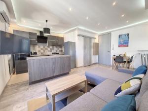 a living room with a couch and a kitchen at Nestor&Jeeves - PALAIS HISPANIA - Top floor apartment in Nice