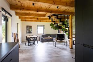 a kitchen and living room with wooden ceilings at Sosnowy Plan in Józefów
