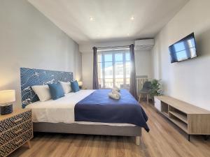 a bedroom with a large bed with a tv on the wall at Nestor&Jeeves - PALAIS HISPANIA - Top floor apartment in Nice