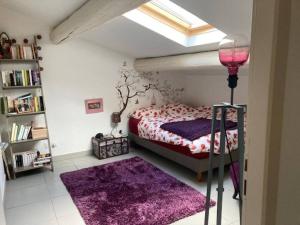 ein Schlafzimmer mit einem Bett und einem lila Teppich in der Unterkunft Loft au cœur de Nîmes in Nîmes