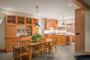 a kitchen with wooden cabinets and a wooden table and chairs at Pismo Cottages on Wadsworth in Pismo Beach