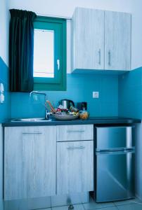 a kitchen with blue walls and a counter with a sink at ANCIENT MEROPIA - Eden in Apollonia