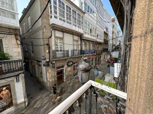 a woman walking down a city street with buildings at Oktheway Real 45 in A Coruña