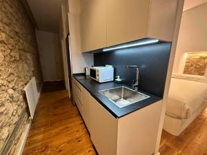 a kitchen with a sink and a microwave on a counter at Oktheway Real 45 in A Coruña