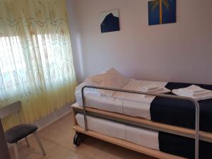 a small bedroom with a bunk bed and a chair at Main square apartment in Durrës