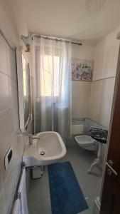 ein weißes Bad mit einem Waschbecken und einem WC in der Unterkunft La Torre in Castiglion Fiorentino