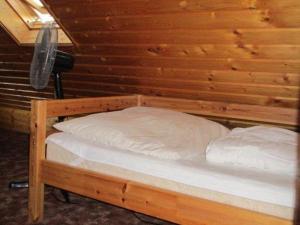 Bett in einem Zimmer mit einer Holzwand in der Unterkunft Ferienhaus der Familie Demmler in Crottendorf