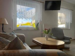 sala de estar con sofá, mesa y ventana en Ferienhaus-der-Familie-Demmler, en Crottendorf