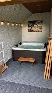 a large bath tub in a room with a bench at Domek w centrum in Zawoja