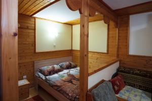 a room with a bed in a wooden cabin at Négy Évszak Vendégház in Lukácsháza