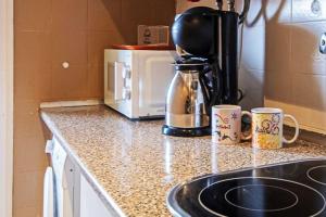 a kitchen counter with a coffee maker and a microwave at Apartamento Bro Mar in Salou