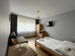1 dormitorio con 1 cama, 1 silla y 1 mesa en Abal en Jastrzębia Góra