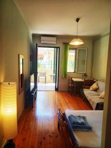 una camera con letto e un soggiorno con tavolo di Valaoritou Apartment a Città di Lefkada