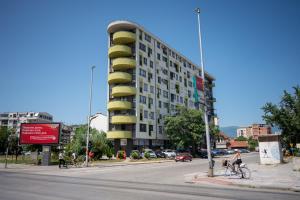 um edifício numa rua da cidade com pessoas a andar de bicicleta em Skopje Station Apartment em Skopje