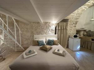 een slaapkamer met een groot bed en handdoeken bij Bianco Calce - Ostuni in Ostuni