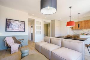 a living room with a white couch and a kitchen at Sitges Spaces Mediterranean Penthouse in Sitges