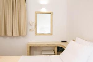 een slaapkamer met een bureau, een spiegel en een bed bij Phevos Villa in Perissa