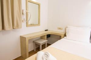 Schlafzimmer mit einem Bett und einem Schreibtisch mit einem Spiegel in der Unterkunft Phevos Villa in Perissa