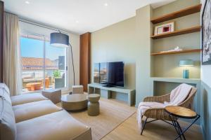 a living room with a couch and a tv at Sitges Spaces Mediterranean Penthouse in Sitges