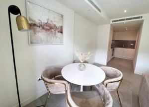 uma sala de jantar com uma mesa branca e cadeiras em Luxury 1 Bed Apt With Pool Access In Eurocity em Gibraltar