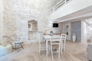 ein weißes Esszimmer mit einem weißen Tisch und Stühlen in der Unterkunft Bianco Calce - Ostuni in Ostuni