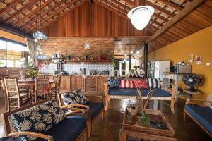 ein Wohnzimmer mit Sofas und einem Tisch sowie eine Küche in der Unterkunft Casa na rocha com uma vista deslumbrante in Itupeva