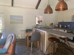 a kitchen with a counter and a table and chairs at Downrow Barn in Tintagel