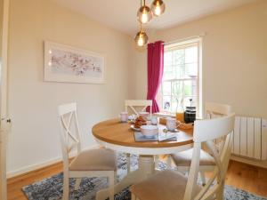 ein Esszimmer mit einem Holztisch und Stühlen in der Unterkunft Holly Leaf Cottage - Drum Castle Estate in Banchory