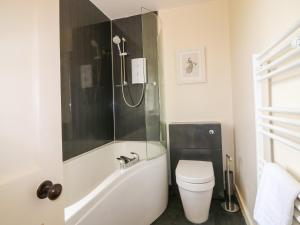 a bathroom with a tub and a toilet and a shower at Holly Leaf Cottage - Drum Castle Estate in Banchory +14 photos