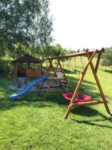 eine Schaukel und einen Spielplatz mit Pavillon in der Unterkunft Domki u Oli in Kudowa-Zdrój