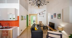 a living room with a couch and a kitchen at Dimore Anna Maria -Il Magazzino- in Avola