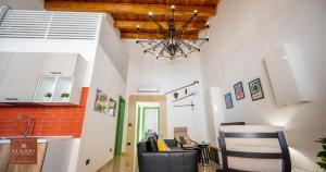 a kitchen with a chandelier and a living room at Dimore Anna Maria -Il Magazzino- in Avola